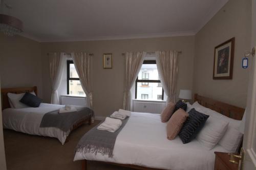 a bedroom with two beds and a window at Lizzys Little Kitchen Town Accommodation in Listowel