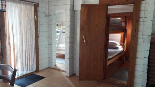 a room with a wooden door and a room with a window at Mellangårds stugor - Stockstugan in Föglö