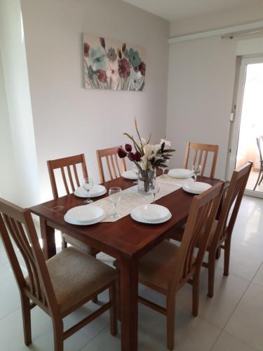 a wooden table with chairs and a vase of flowers at Apartment Juliette in Zadar