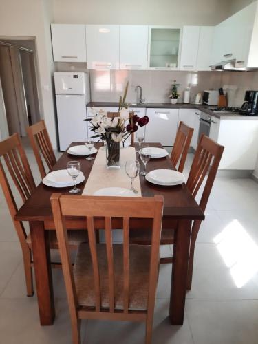 a wooden table with chairs and a vase of flowers at Apartment Juliette in Zadar