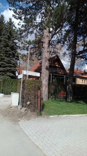 a house with a sign next to a tree at Apartman Ristivojevic Zlatibor in Palisad