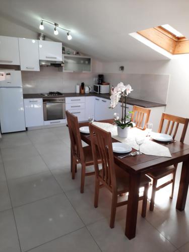 a kitchen with a wooden table with chairs and a dining room at Apartment Juliette in Zadar