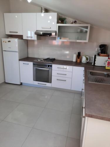 a kitchen with white cabinets and a stove at Apartment Juliette in Zadar