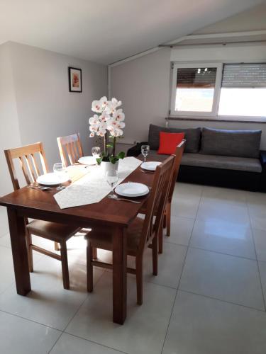 a wooden dining room table with chairs and a couch at Apartment Juliette in Zadar