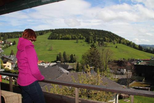 a woman standing on a balcony looking at a valley at Gästehaus Wissler in Todtnau