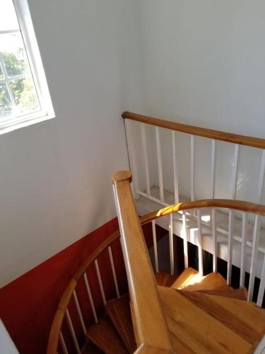 a wooden spiral staircase in a room with a window at Caribbean estate deluxe 2 in Portmore
