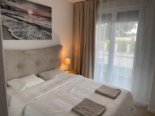 una camera con un letto bianco e una finestra di Brand new apartment with gym&rooftop pool. a Marbella