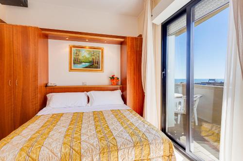 - une chambre avec un lit et une grande fenêtre dans l'établissement Hotel Delle Nazioni, à Milano Marittima