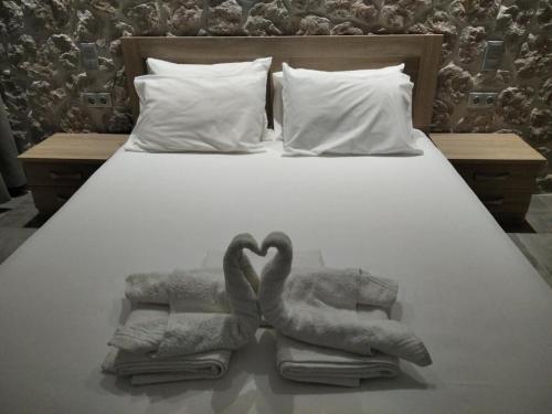twee zwanen gemaakt van handdoeken op een bed bij Estia - Brand new apartment in Ermioni Village in Ermioni