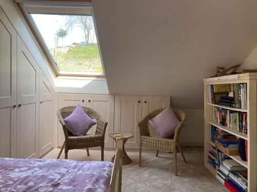 1 dormitorio con tragaluz y 2 sillas con almohadas moradas en Cosy twin room with private bathroom en Kent