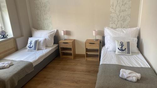 dwa łóżka w pokoju z dwoma stolikami nocnymi w obiekcie Willa Andersa w mieście Ruciane-Nida