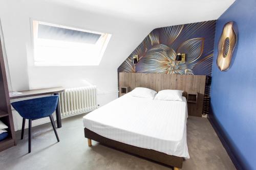 a bedroom with a bed and a desk and a window at Hotel Iena in Angers