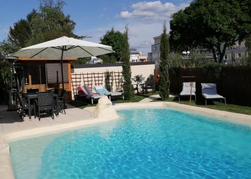 een zwembad met een parasol en een tafel en stoelen bij Belle Etage geräumige Ferienwohnung mit Pool und Sauna in Lorsch