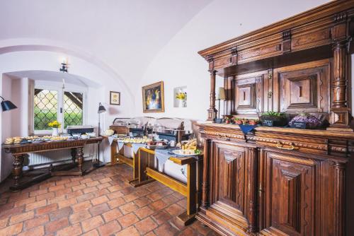 トレボンにあるpenzion Dvorceの木製キャビネットとテーブル付きの広いキッチンが備わります。