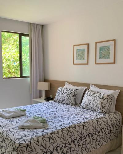 a bedroom with a large bed with a comforter at Apartamento flat - Iloa Residence 1 in Barra de São Miguel