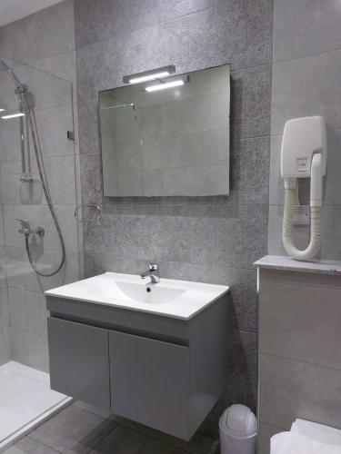 a bathroom with a sink and a shower with a mirror at Casa Birmula Boutique Hotel in Cospicua
