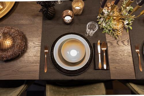 a table with a plate and spoon and fork and knife at LOFT d'O in Ypres