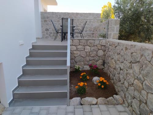 a set of stairs leading up to a house with flowers at Armonia - Brand new apartment in Ermioni Village in Ermioni