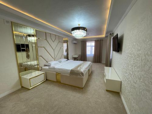 Shohjahon Palace Hotel & Spa في سمرقند: غرفة نوم بسرير كبير ومرآة