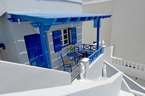 a model of a house with blue doors and chairs at Lunar Santorini Hotel in Perissa