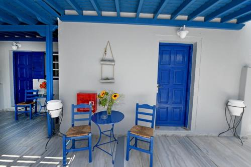 a room with a table and chairs and a blue door at Lunar Santorini Hotel in Perissa