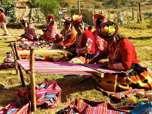 a group of people sitting on the ground with hats on their heads at Ayllu B&B Ollantaytambo in Ollantaytambo