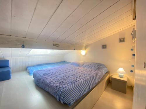 um quarto com uma cama com um edredão azul em La Maison Bleue em Gruissan