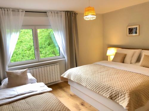 a bedroom with two beds and a window at Angel Boutique Home - Entire premium house in Laško