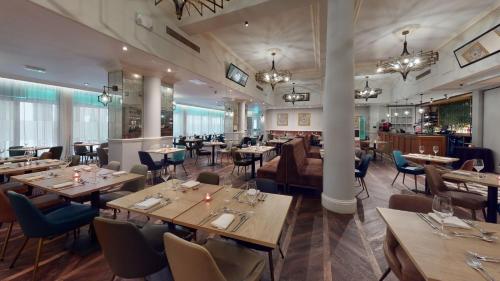 a restaurant with wooden tables and chairs and a bar at The Queen at Chester Hotel, BW Premier Collection in Chester