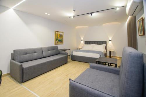 a living room with a bed and a couch at Palm Side Hotel in Vlorë