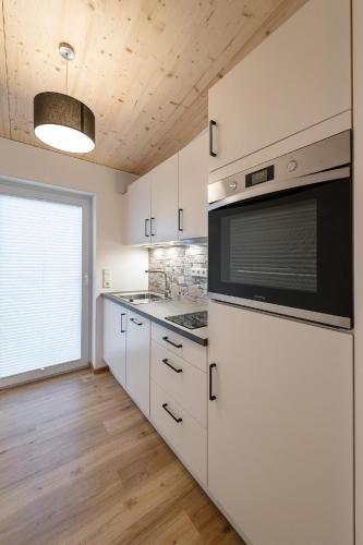 a kitchen with white cabinets and a stove top oven at Gästezimmer/Appartement Familie John in Veitsbronn