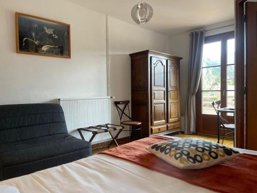 a bedroom with a bed and a couch and a window at Auberge du Point Sublime in Rougon