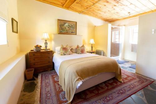 a bedroom with a bed and a wooden ceiling at Onbedacht Cottage in Graaff-Reinet