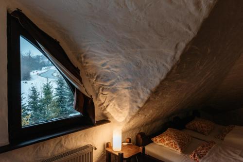 ein Schlafzimmer mit einem Fenster und einer schneebedeckten Decke in der Unterkunft Gęsi Zakręt in Ustrzyki Dolne