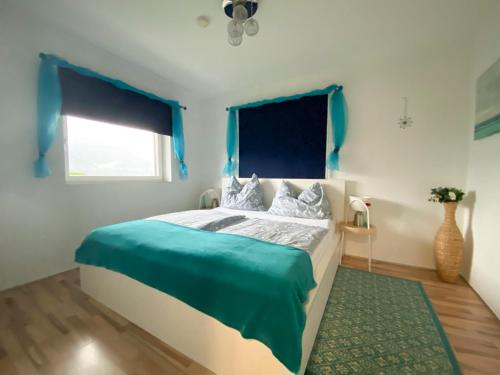 a bedroom with blue walls and a bed with a green rug at Rosentalferien in Ludmannsdorf