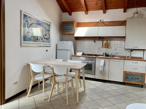 une cuisine avec une table et des appareils électroménagers blancs dans l'établissement Il Nido, à Castelletto sopra Ticino