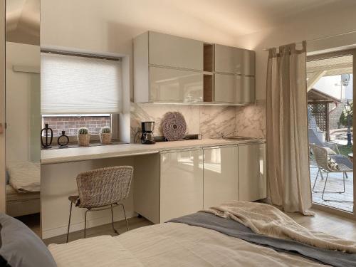 a bedroom with a bed and a kitchen with a window at Domek Mrągowo in Mrągowo