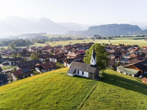 a small village with a church on a hill at Landhaus Bergidyll - Ferienwohnung Kapellenblick in Bolsterlang