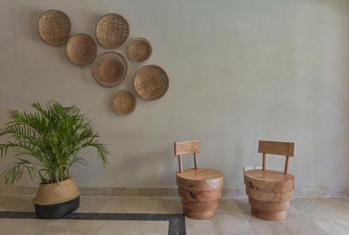 The Bay Hotel Hurghada Marina في الغردقة: كرسيين وسلات على جدار مع نبات