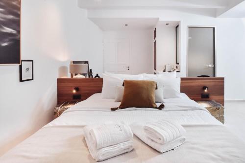 a bedroom with a large white bed with two towels on it at Ikaros Suites in Amoudara Herakliou