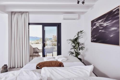 a bedroom with two beds and a balcony at Ikaros Suites in Amoudara Herakliou