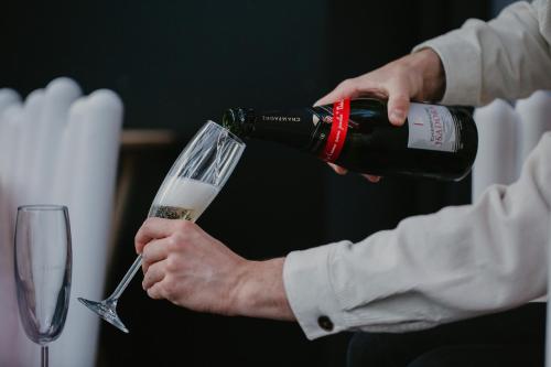 a person pouring a bottle of wine into a glass at L'intimiste in Longeville-sur-Mer