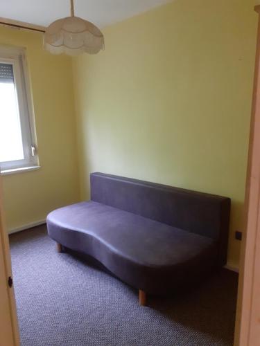a blue couch in a room with a window at Jókai Apartman Békéscsaba in Békéscsaba