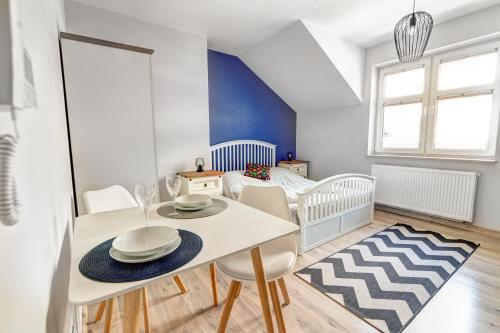 - une salle à manger avec une table, des chaises et un berceau dans l'établissement Rentimi - Apartament Skandynawski 2, à Krynica-Zdrój