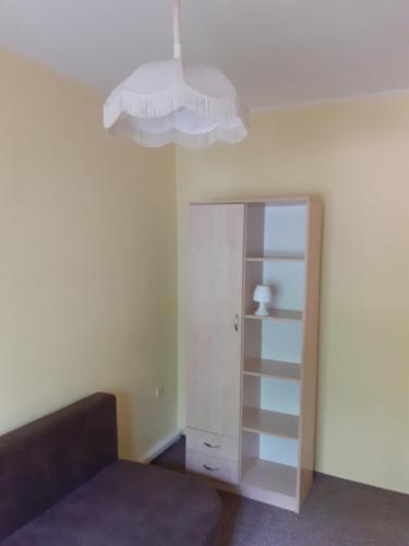 a room with a bed and a chandelier at Jókai Apartman Békéscsaba in Békéscsaba
