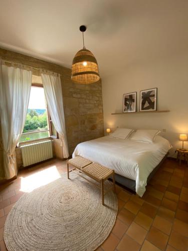 Tempat tidur dalam kamar di Les Courtines - Appartement de caractère à la Roque-Gageac - Les Chênes Verts