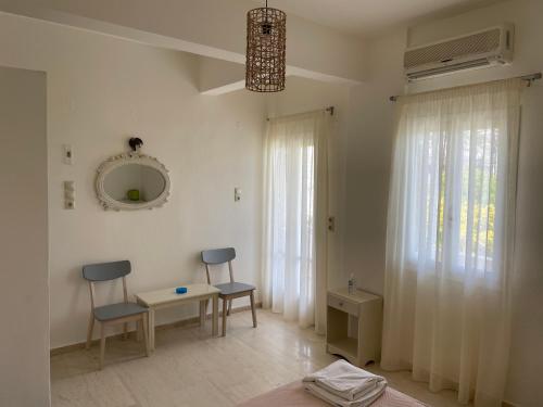 a living room with two chairs and a table and a mirror at Villa Sylvia in Matala