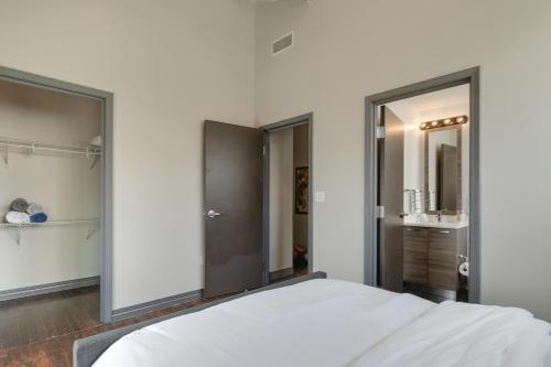 a white bedroom with a bed and a bathroom at Luxury Downtown Dallas Stay by Amyfinehouse in Dallas