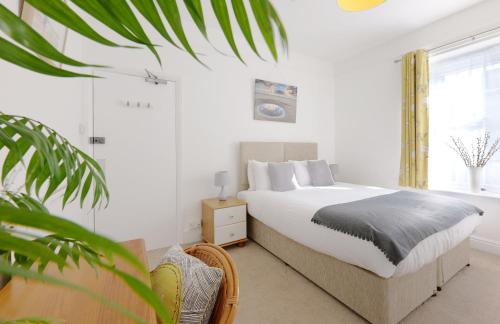 a white bedroom with a bed and a window at Tee-Side Guest House in Bude