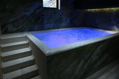 a large blue tub in a bathroom with stairs at Hotel Onufri in Golem